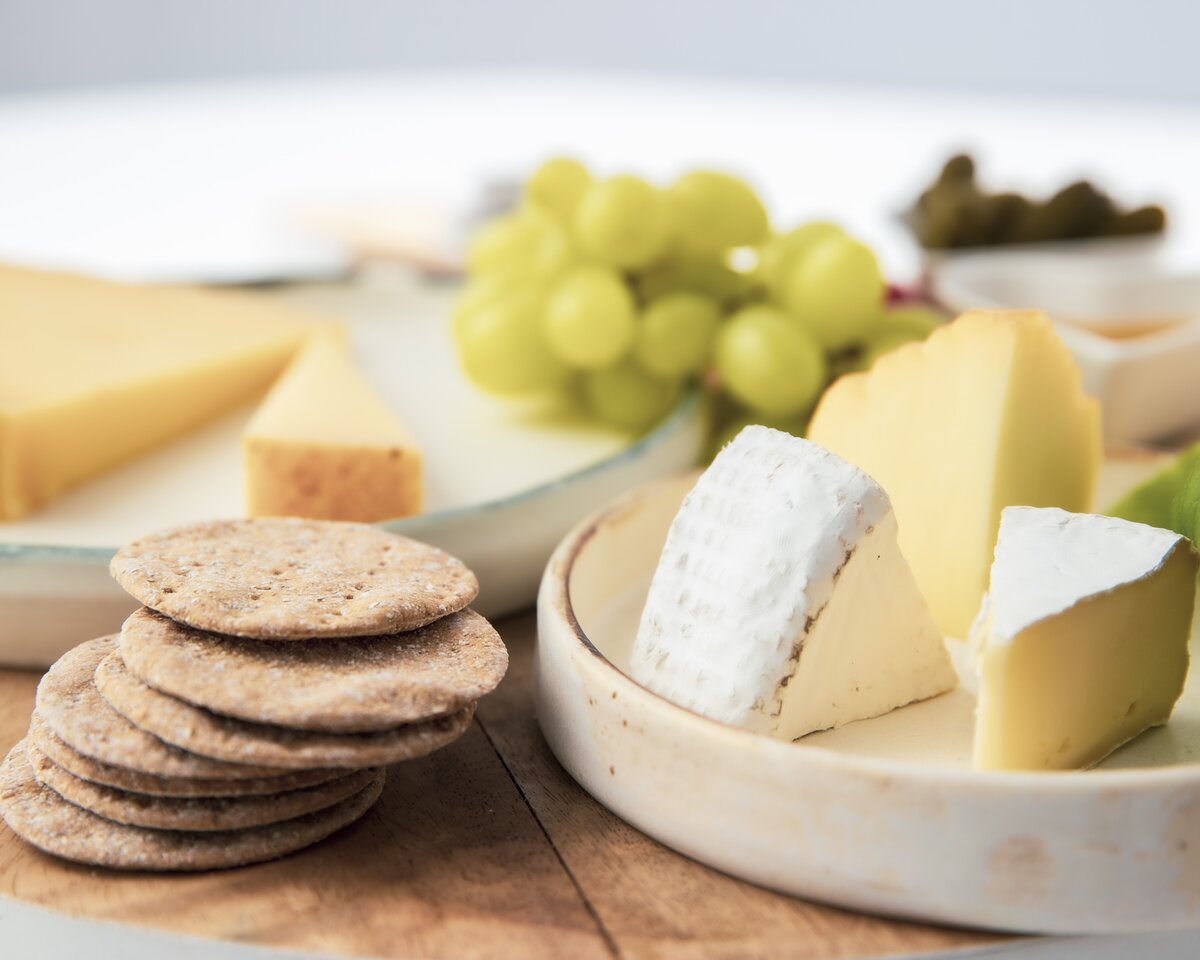 Camembert cheese bites with crackers and grapes.