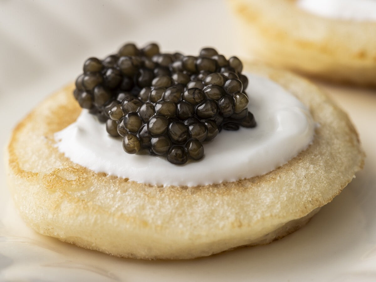 Black caviar from the the best fish egg roe served on a blini with creme fraiche.