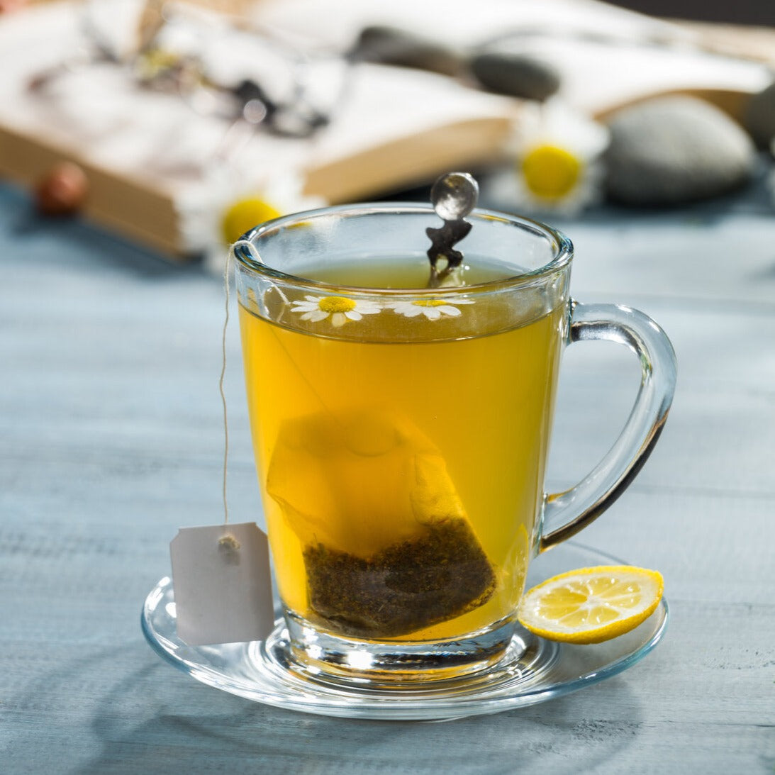 Easy to brew chamomile tea bag in a cup with honey and a slice of lemon.
