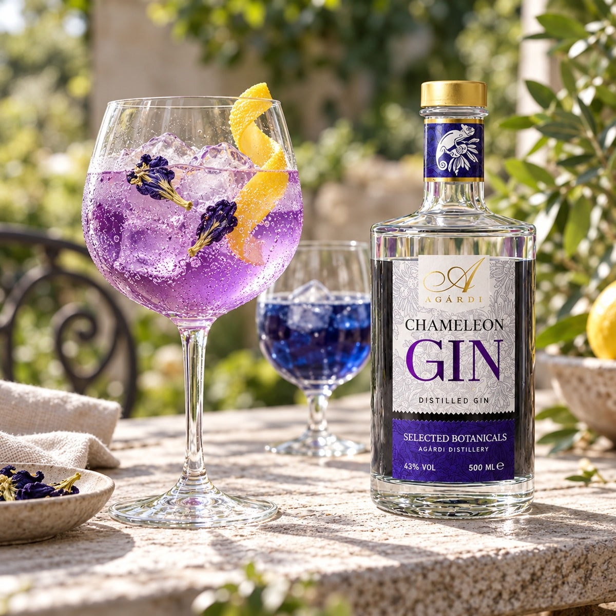 A glass of a purple gin and tonic cocktail made with a blue bottle of Chameleon colour-changing gin.