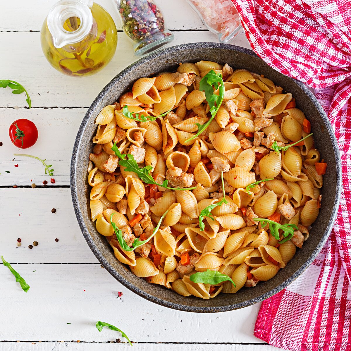 A bowl of sesame conchiglie noodles, these seashell shaped pasta are served with a meat ragout in a tomato sauce.