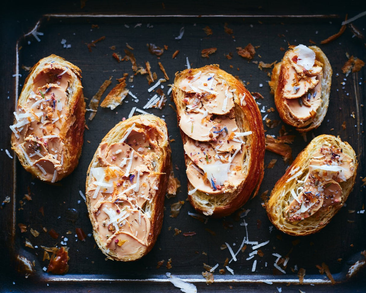 Whole pieces of duck liver foie gras on brioche buns with red onions.