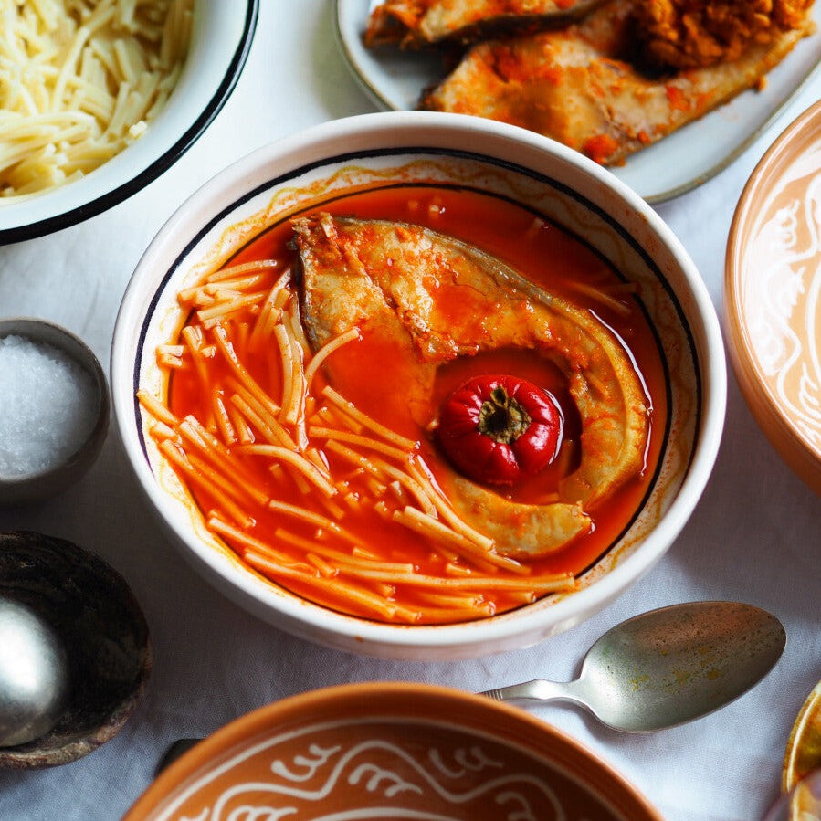 A bowl of Halászlé, a Hungarian fish soup recipe, served with traditional Gyufatészta pasta.