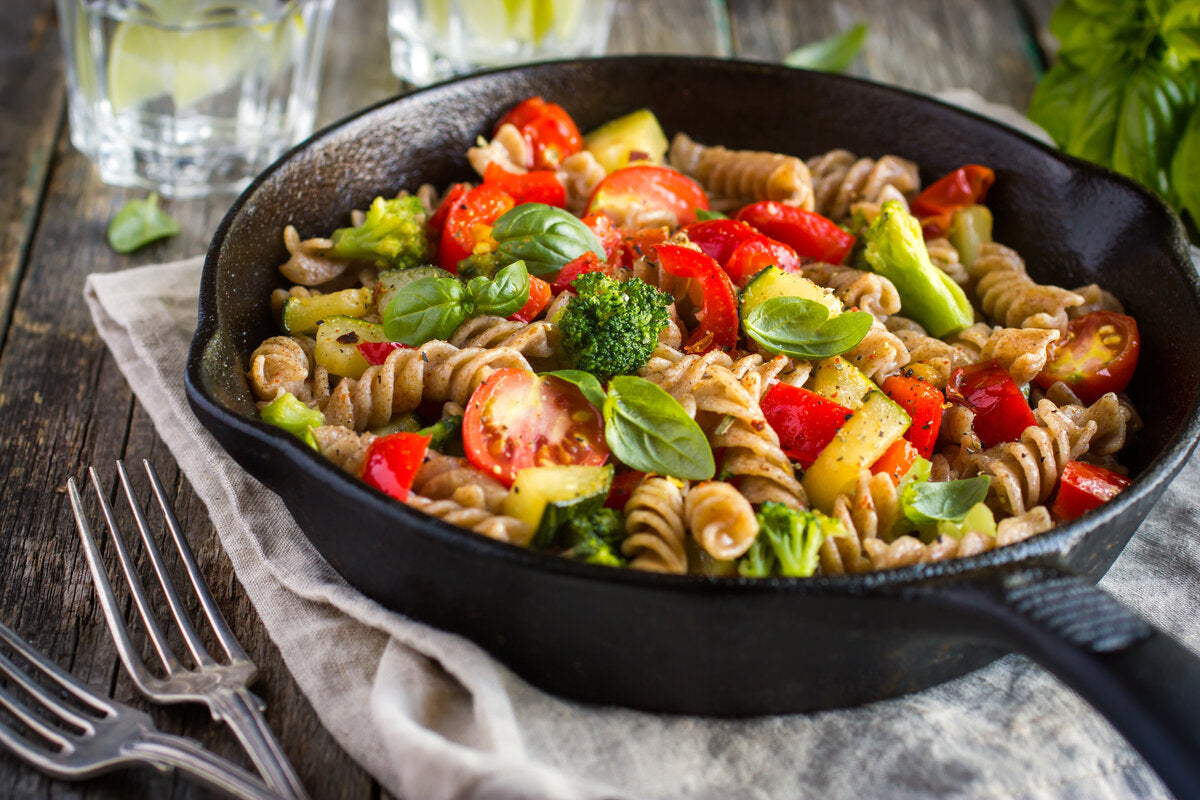 A bowl of gluten free oat fusilli pasta with roasted vegetables.
