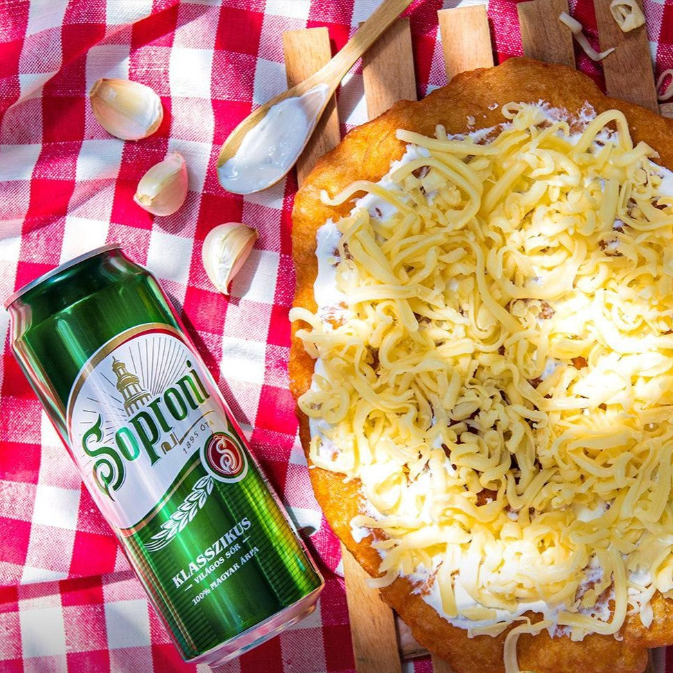 A lángos Hungarian fried bread dough from Budapest with a can of Soproni beer.
