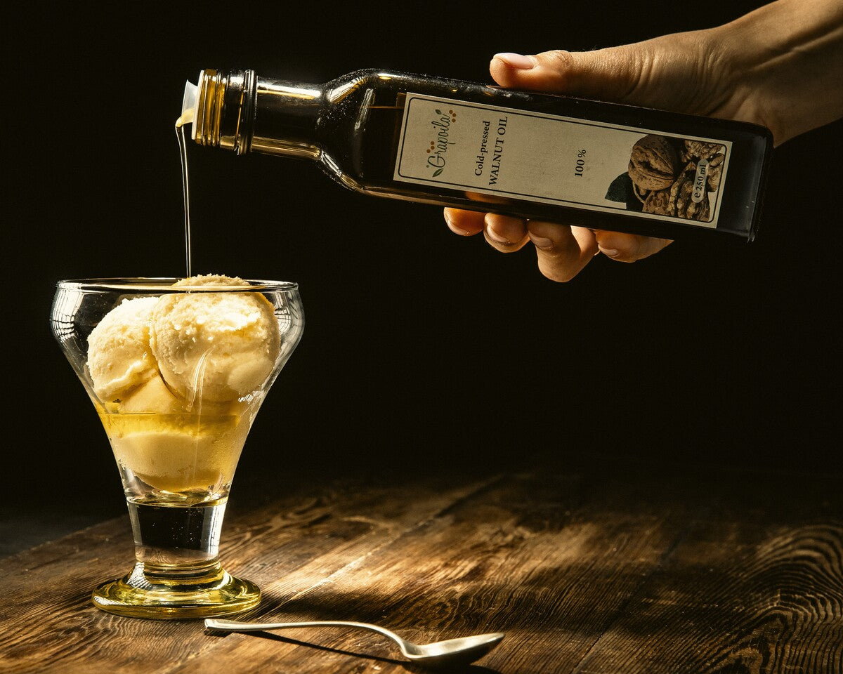 Vanilla ice cream in a glass bowl with a drizzle of walnut oil.