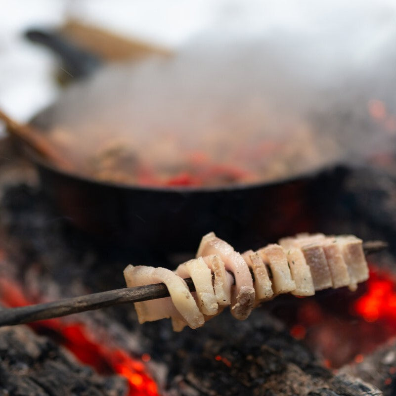 Magyar sült szalonna roasting over fire.
