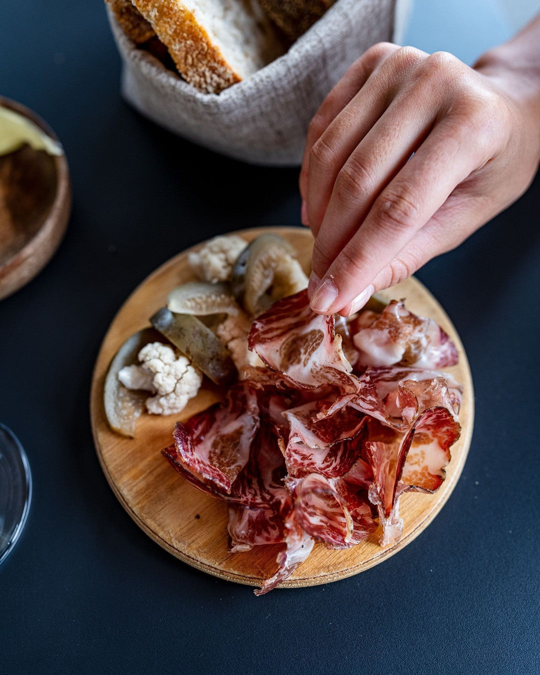 Air-dried pork coppa slices with cheese and bread.