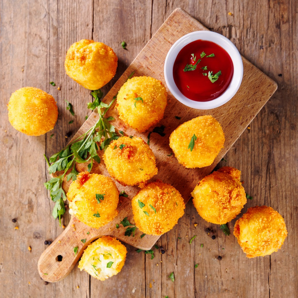 Crispy potato balls with a bowl of all-healthy ketchup from all-natural ingredients.