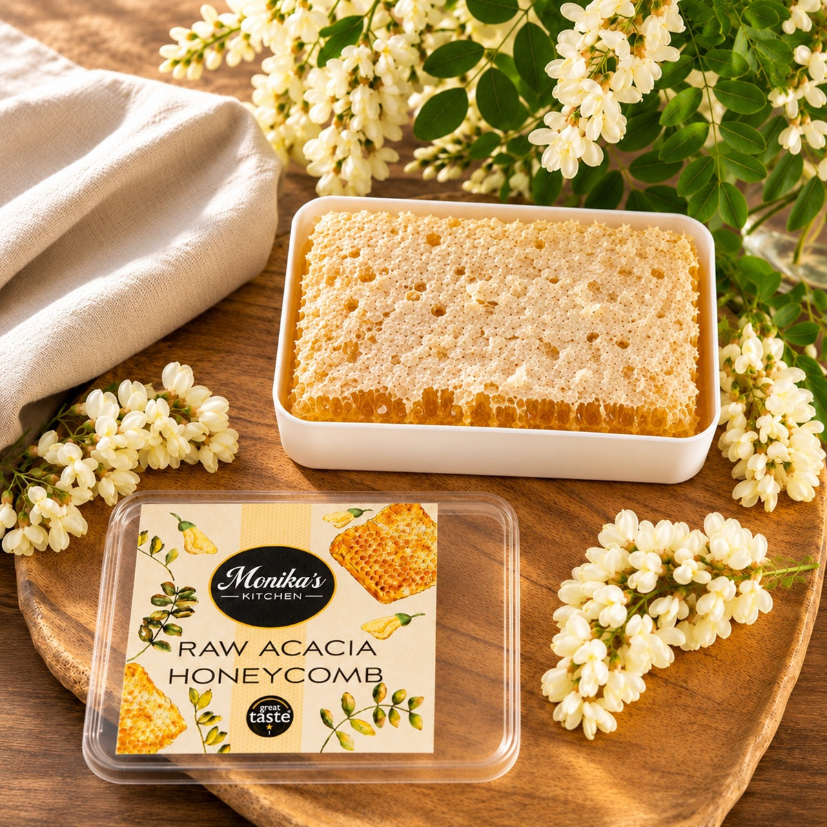 A piece of pure and natural raw honeycomb in a tin on a wooden surface with acacia flowers around.