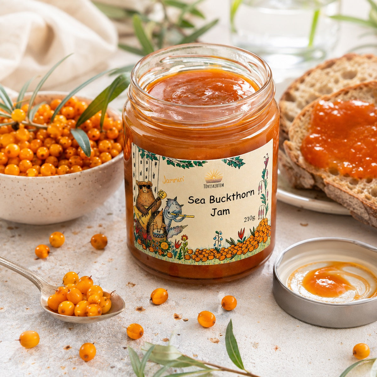 Jar of sea buckthorn jam with a handful of organic sea buckthorn berries.
