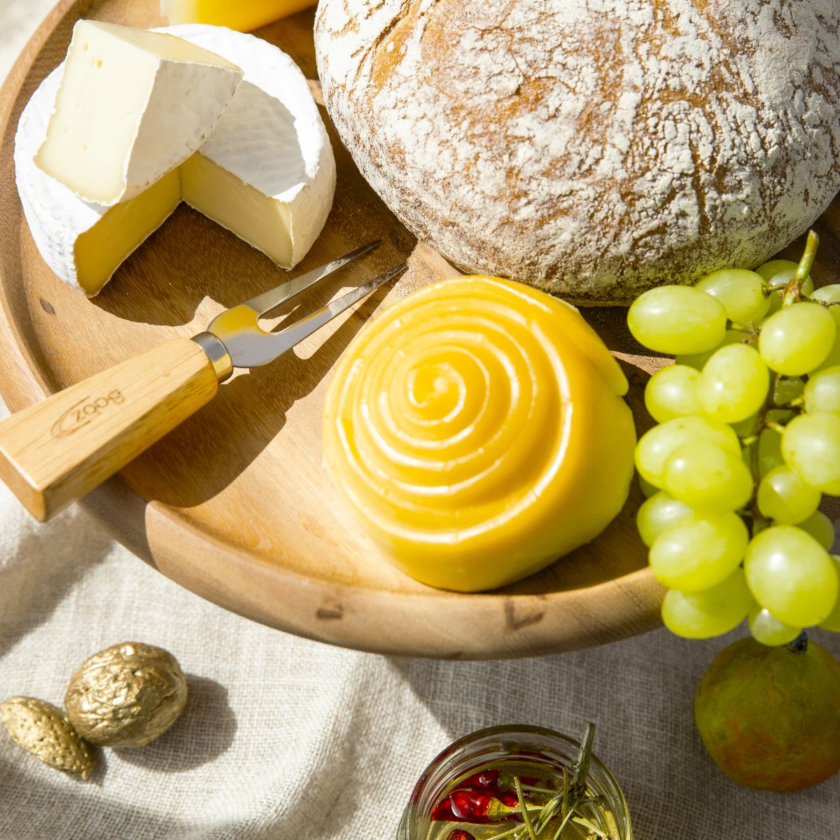A smoky Parenica cheese on a plate, this is the best Hungarian smoked cheese server with grapes and bread.