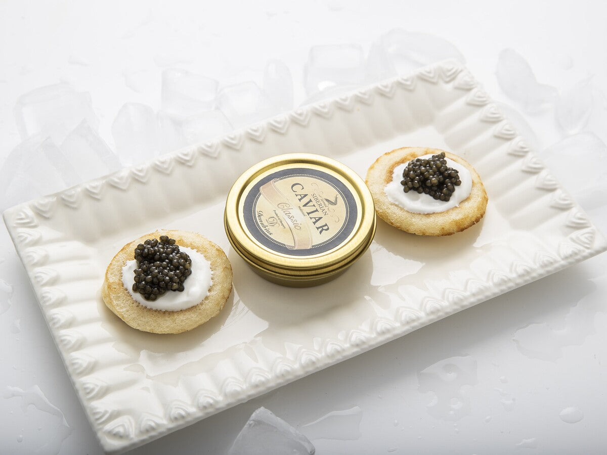A tin of Malossol Siberian sturgeon black caviar from the fish egg roe served on a blini.