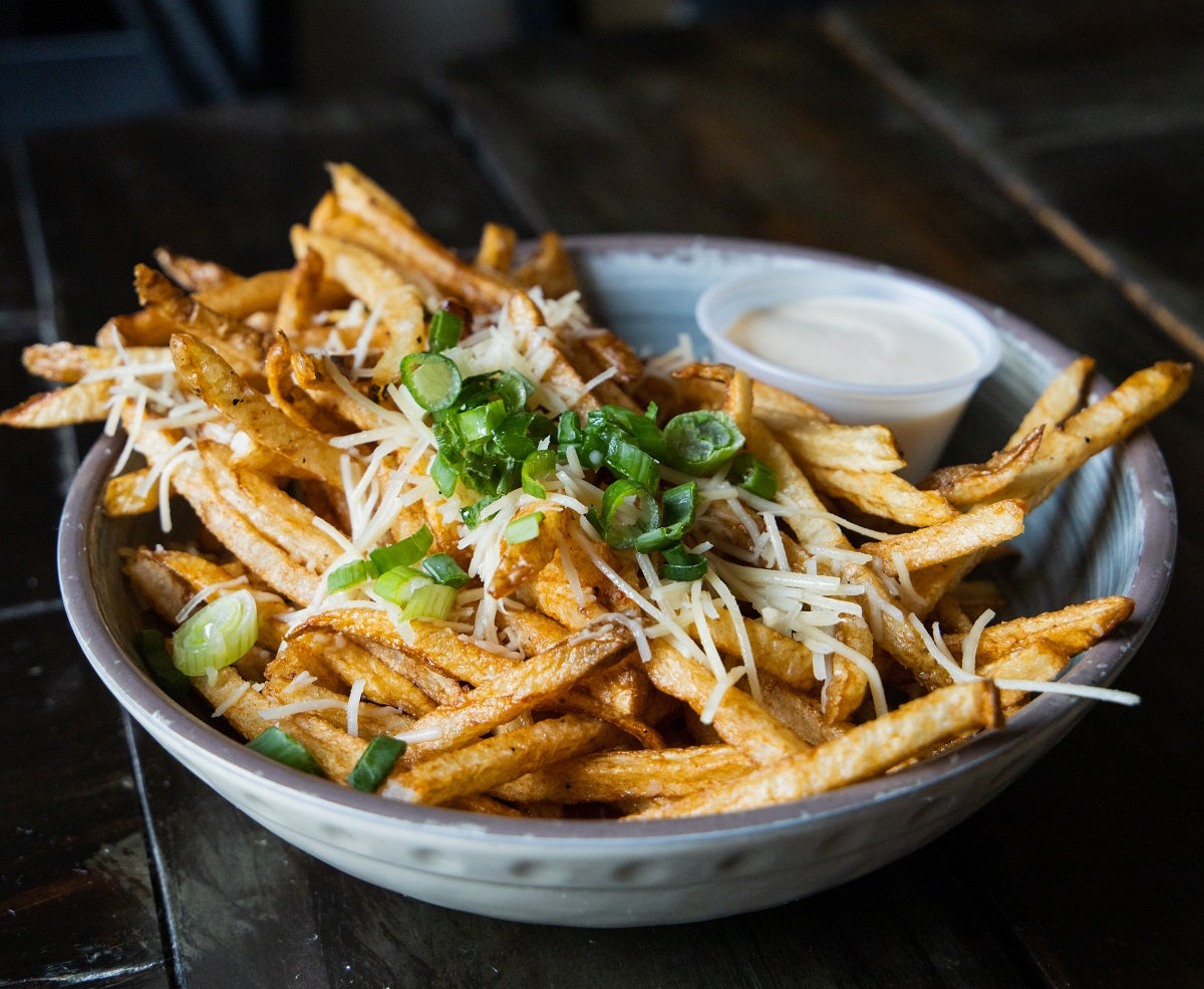 A gourmet truffle French fries recipe seasoned with black truffle powder and served with parmesan cheese.
