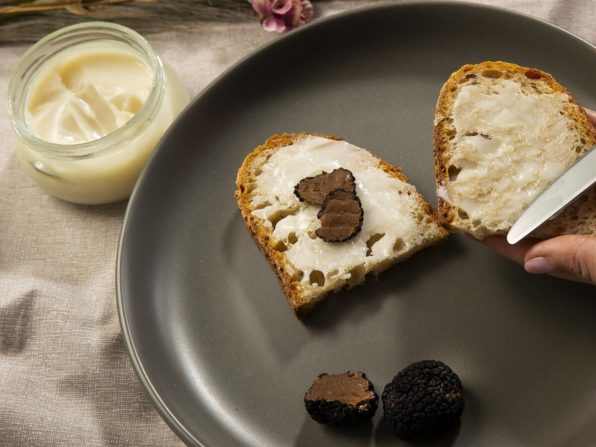 Bread slices buttered with a lard and black truffle spread.