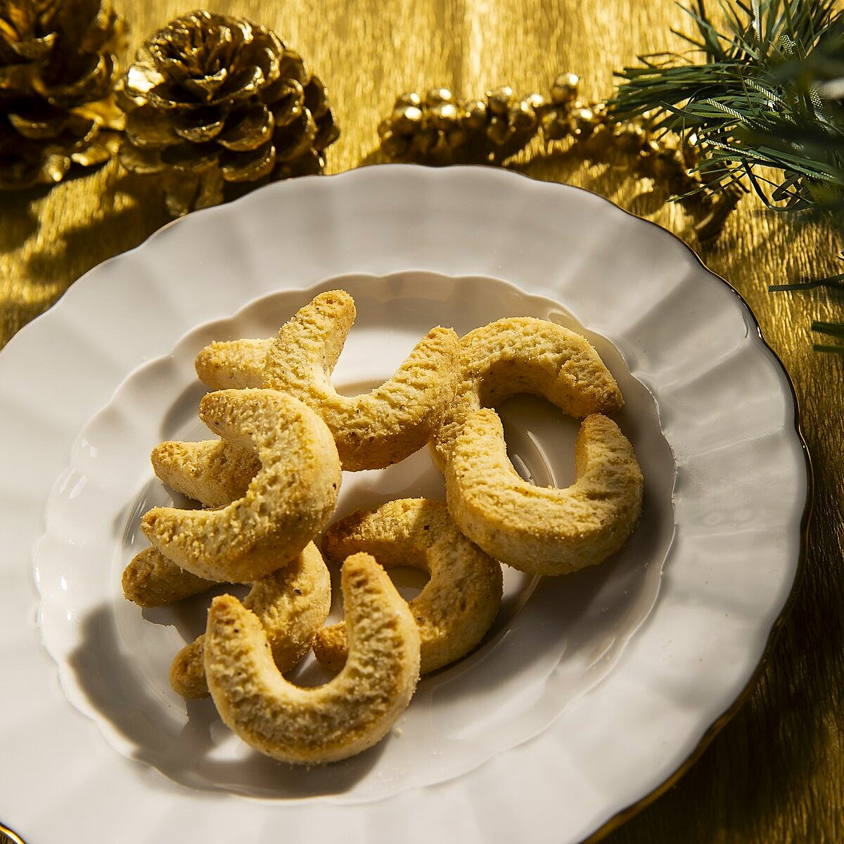 A plate of Vanilla Kipferl crescent cookies made using a traditional Austrian recipe.