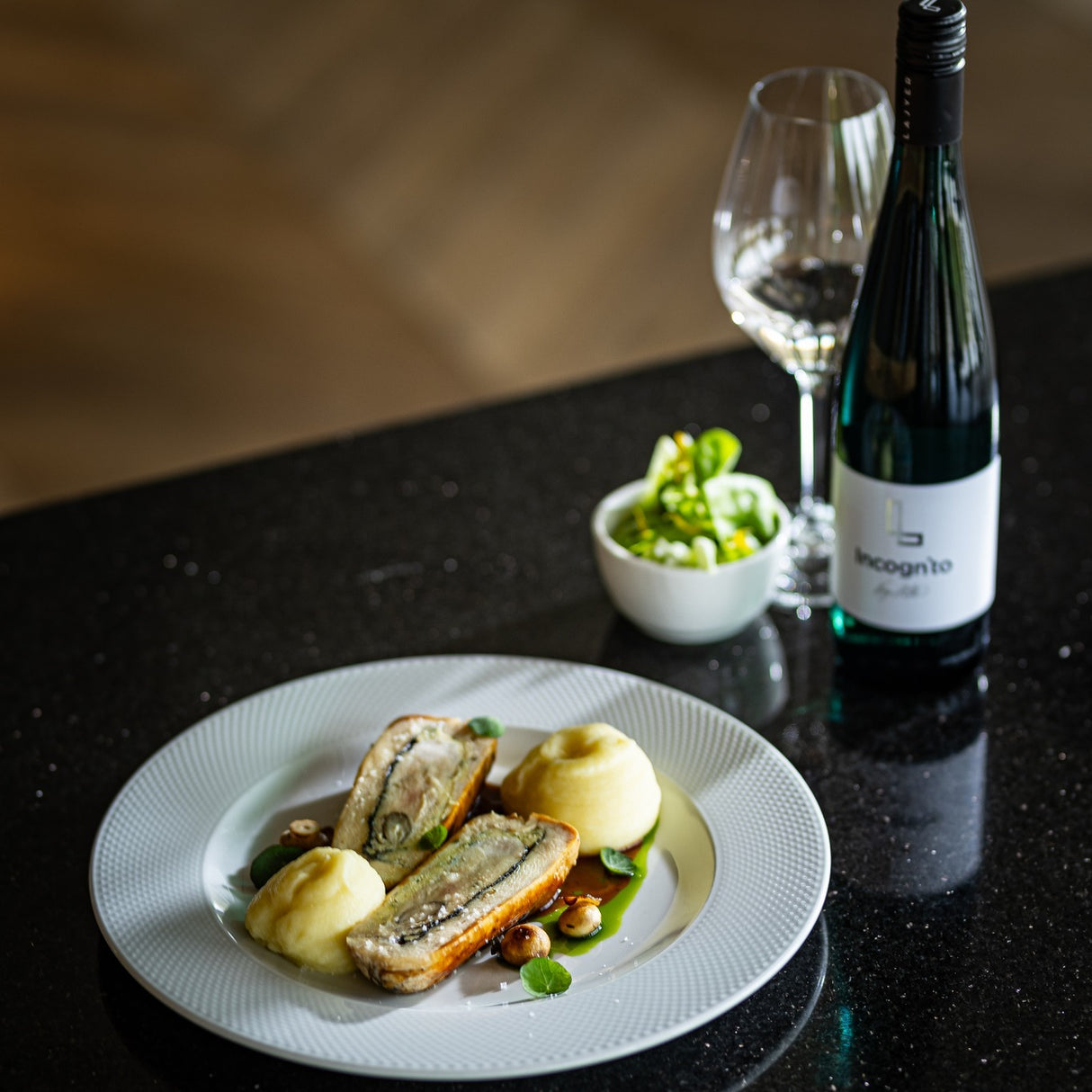 A glass of dry white wine paired with fish and salad.