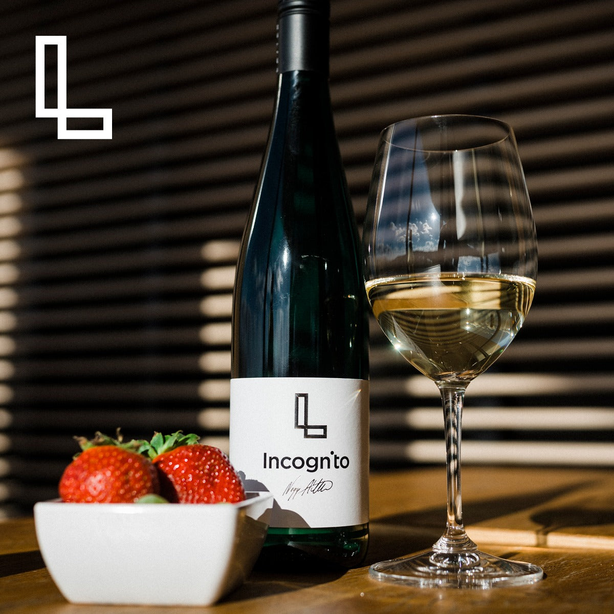 A bottle of dry white wine, paired with fresh strawberries and fruit desserts.