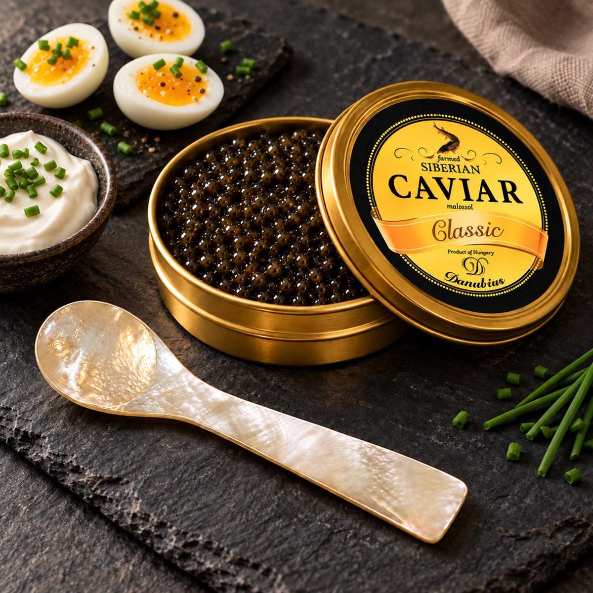 An open tin of Danubius Siberian Sturgeon Caviar with a mother-of-pearl serving spoon.