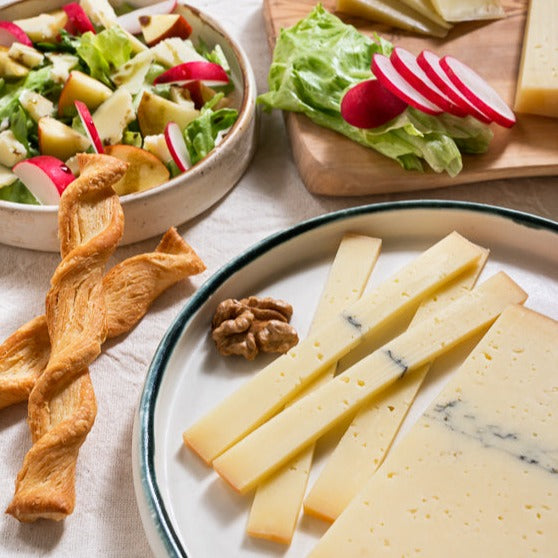 Artisan ash cheese on a plate with crackers and walnut.