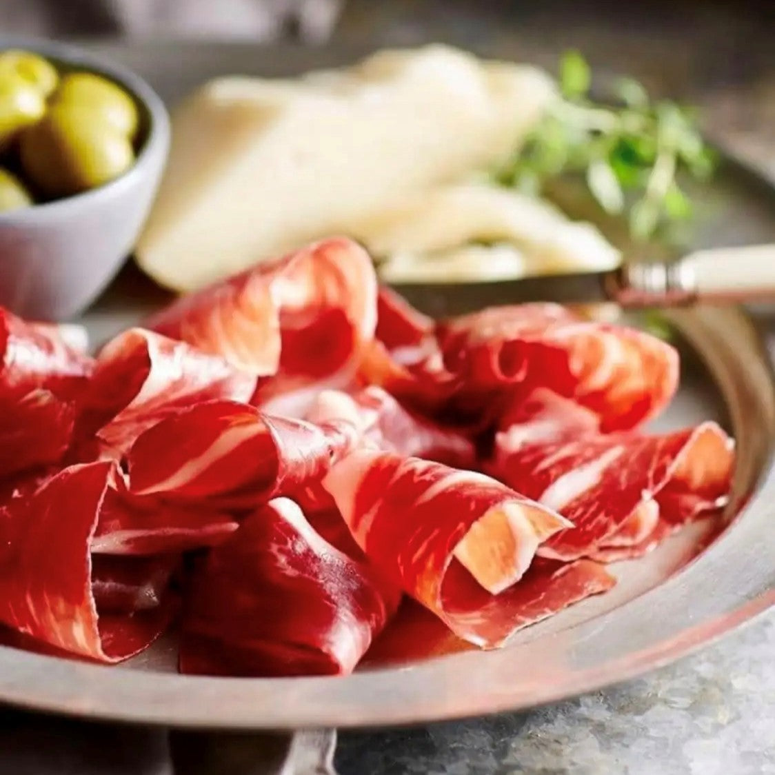 A plate of mangalitza ham carpaccio, these air-dried slices are like the best Italian Serrano.