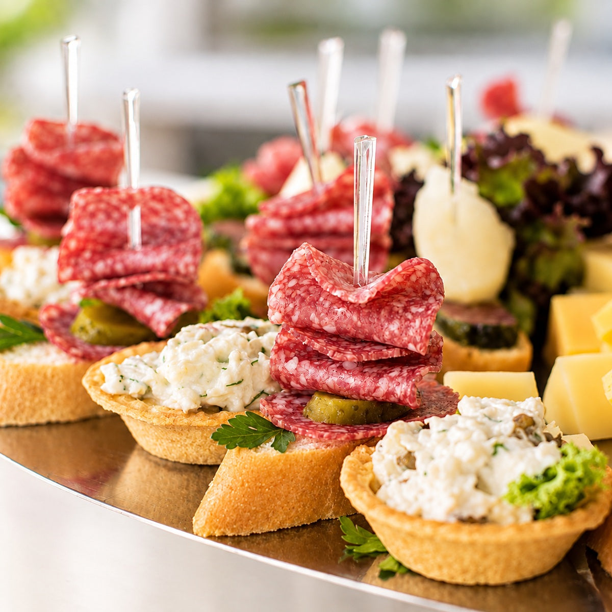 Appetisers on a plate made with Hungarian Pick salami served on toothpick skewers.