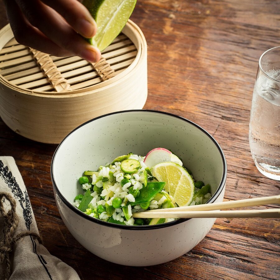 A healthy rice bowl salad with cooked organic white rice, fresh vegetables and lime juice.