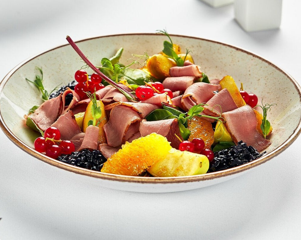 A salad with slices of smoked duck breast carpaccio.