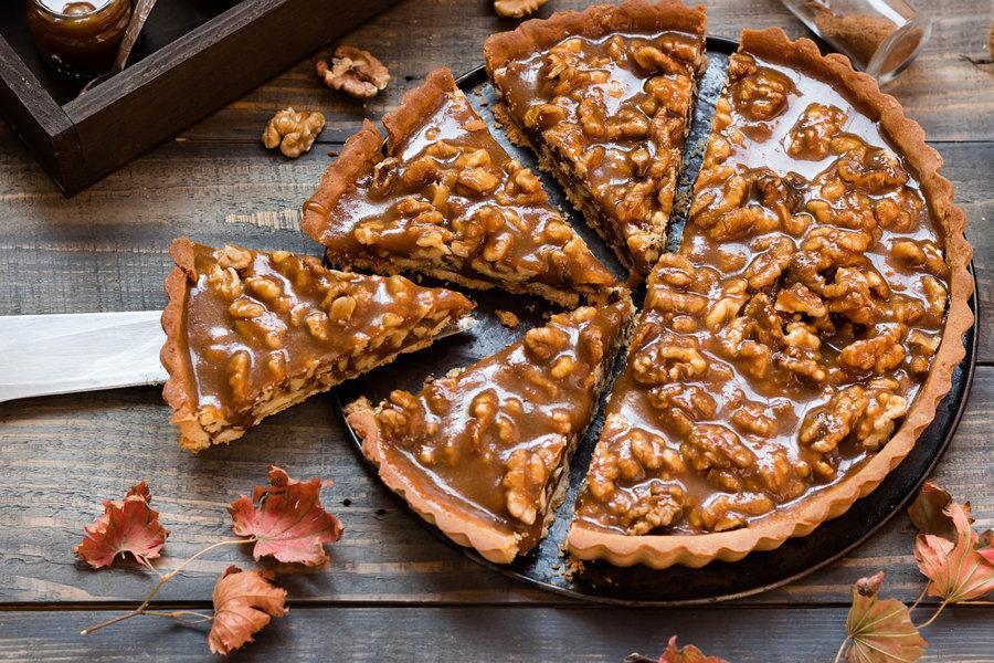 A walnut pie with a crust, made with walnut butter and fresh whole walnut pieces.
