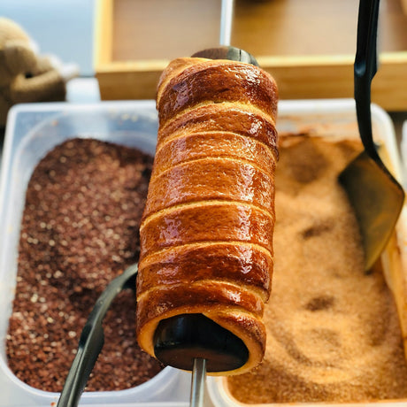 A roll of Kurtos Kalacs,a  trendy Hungarian street food covered in cinnamon sugar.