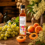 Bottle of Grapoila Balsamic Apricot Vinegar on a wooden table with apricots, elderflowers and grapes.