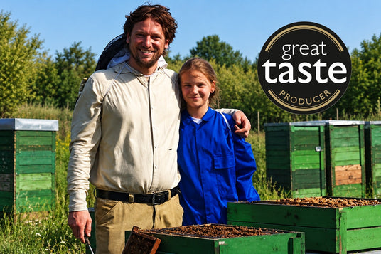 Great Taste Award winning Hungarian artisan beekeeper Laszlo Varaljai with his daughter at the beehives in a wildflower meadow.