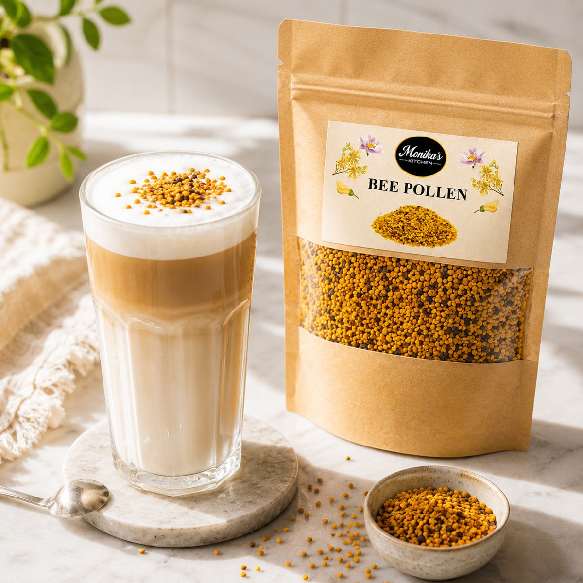 A glass of coffee latte with bee pollen on a marble surface next to a package of Monika's Kitchen Bee Pollen.