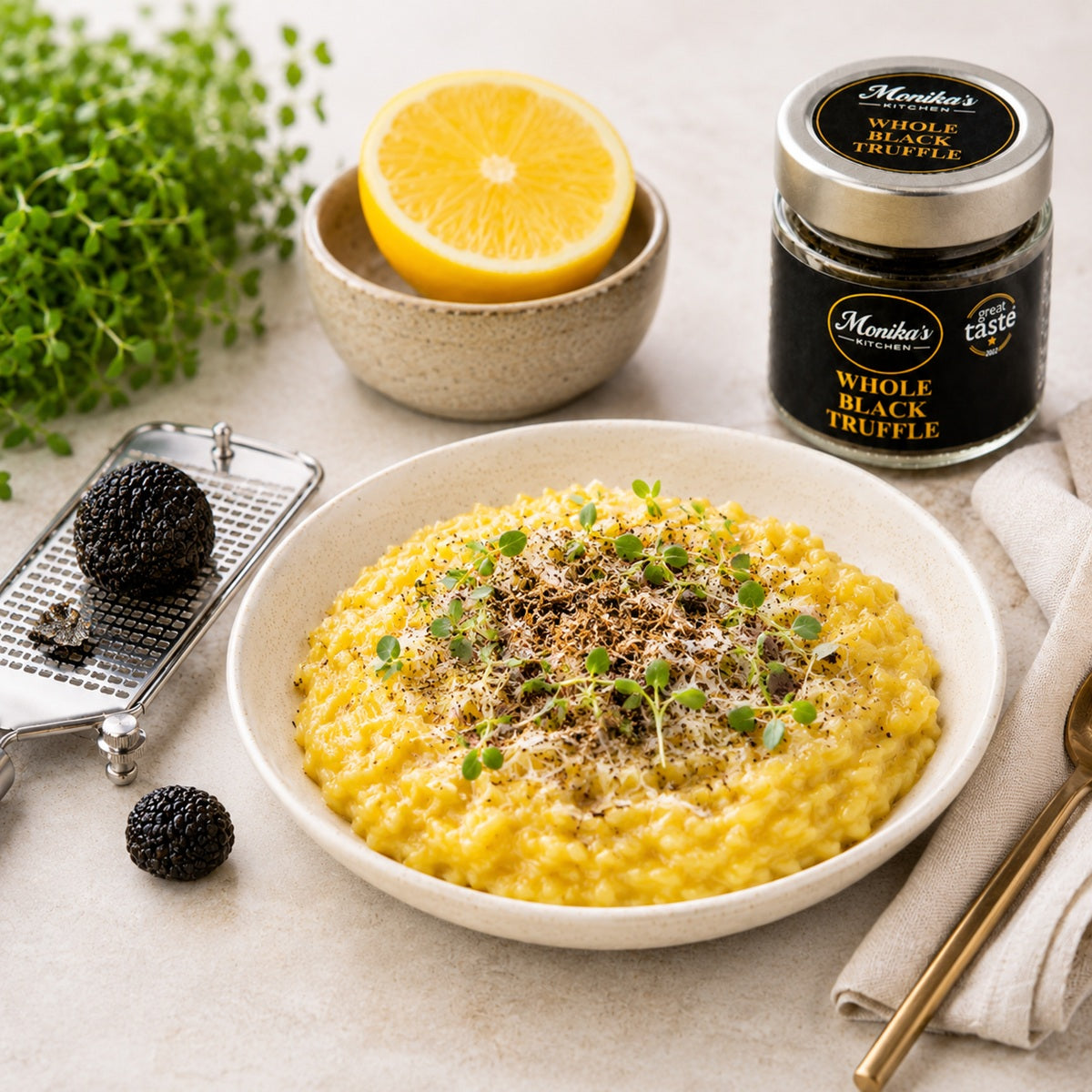Bowl of risotto with grated black truffle, lemon, and herbs, with a jar of whole truffles in the background.