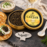 A tin of caviar open next to a metal caviar key, a bespoke tin opener tool with a sturgeon design.