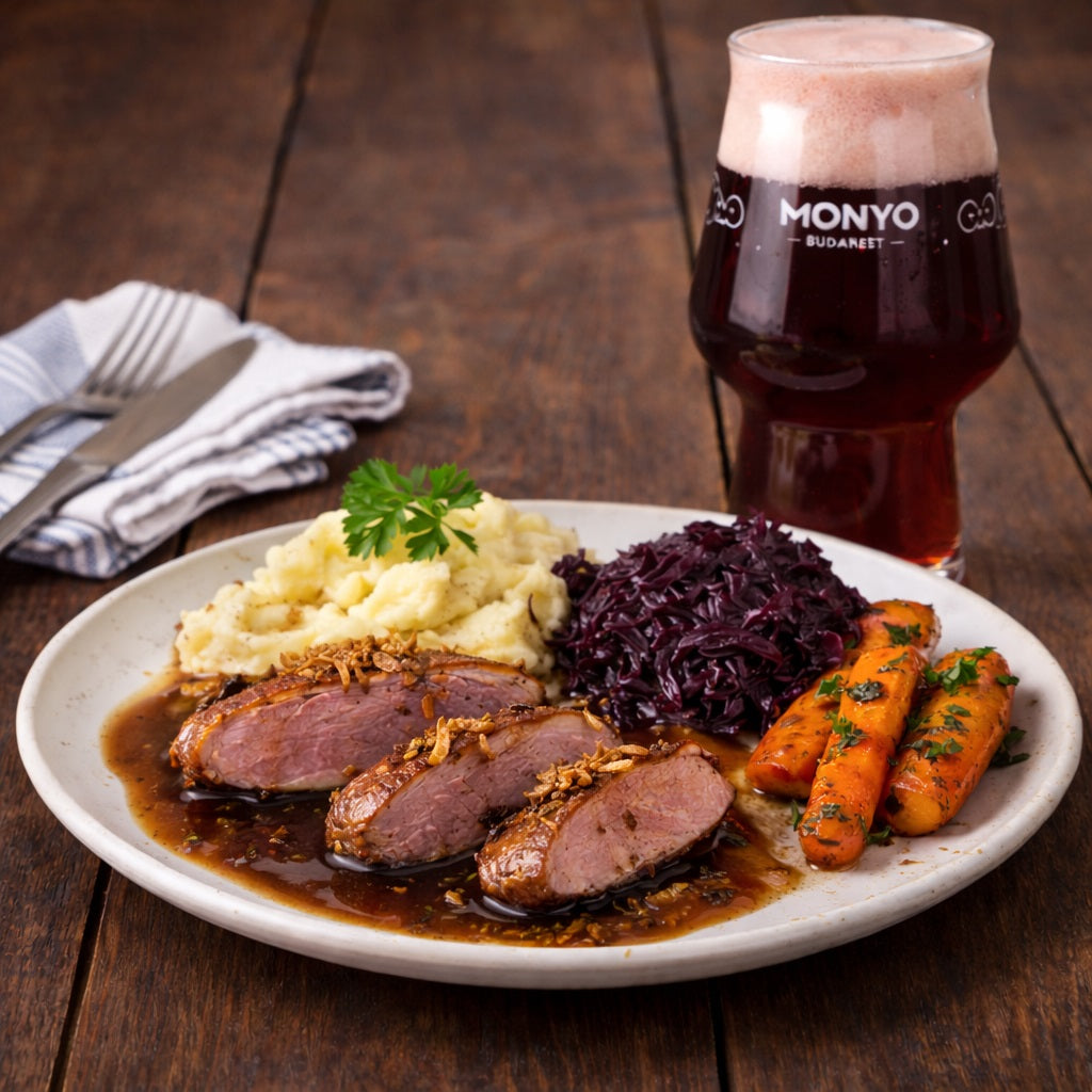 Plate of roast duck with sides on a plate and a glass of cherry beer in the background.