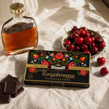 Box of Cherry Liqueur Chocolate, called Lellei Konyakmeggy, with fresh cherries, a bottle of brandy and dark chocolate.