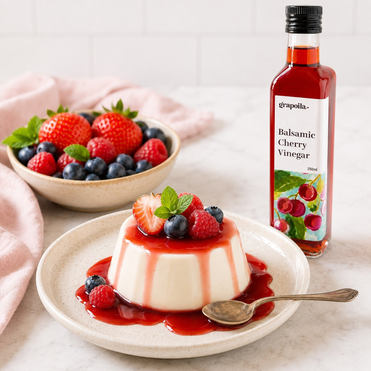 Balsamic Cherry Vinegar drizzled over a panna cotta dessert with berries on a light background