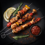 Skewers of grilled chicken with vegetables, accompanied by a bowl of BBQ Ketchup.