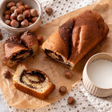 Slices of chocolate babka on a brown paper showing a hazelnut cream filling.