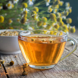 Cup of chamomile tea made with dried chamomile flowers.