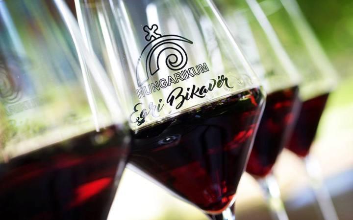 Wine glasses filled with Egri Bikaver Hungarian red wine, featuring the 'Hungarikum' logo.