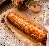 German poppy seed roll on brown paper with a cup of tea.