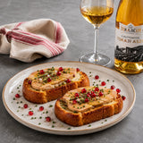 Two slices of toasted brioche bread with goose liver foie gras terrine paired with a glass of Tokaji dessert wine.