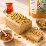 Halva cake made with ground sesame seeds and honey, topped with coarsely chopped nuts.