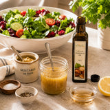 Salad dressing with mustard, vinegar and cold-pressed hazelnut oil from a bottle, with a bowl of green salad in the background.