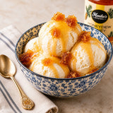 Bowl of vanilla ice cream with honeycomb and honey, jar of Honeydew Honey in the background.