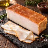 A block of acorn-fed Ibérico bacon: pork tocino made from cured, beechwood-smoked fatback, served on a slate board with wafer-thin slices.