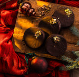 Ischler chocolate cookies on a wooden chopping board with Christmas decorations.
