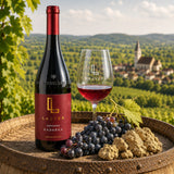 Bottle of Lajver Kadarka wine with a glass of red wine, kadarka grapes and loess soil on a wooden barrel.